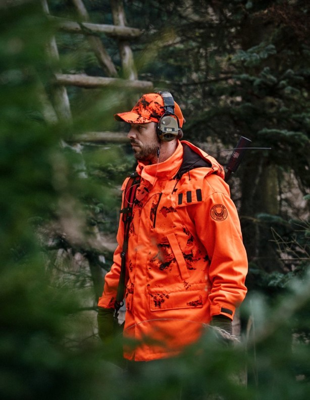 Harkila Wildboar Pro Blaze Camo Jacket - side view of the jacket in the woods.