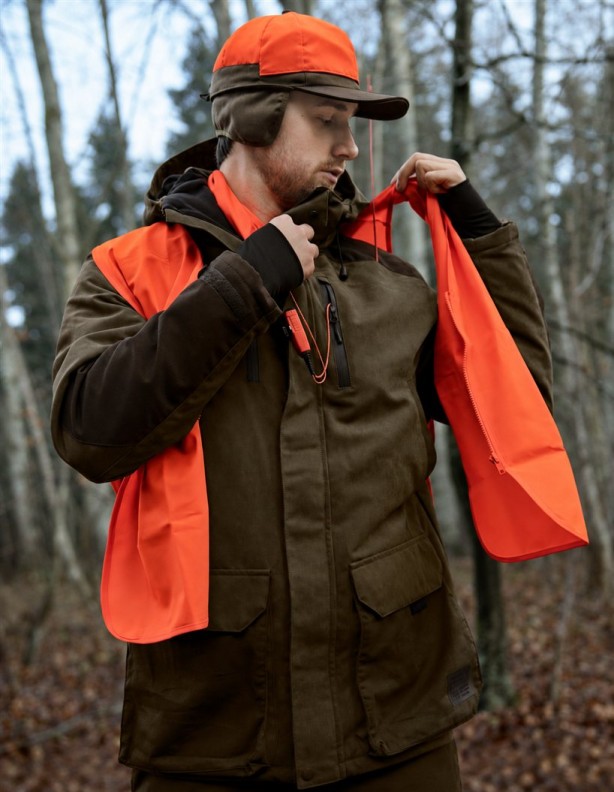 Myśliwy zakładający pomarańczową kamizelkę Seeland Safety Vest